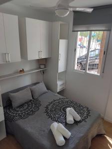 sypialnia z łóżkiem z dwoma białymi butami w obiekcie Apartamento delux2 w Walencji