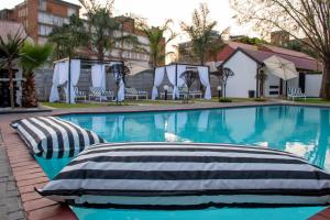 a swimming pool with two pillows on the side at Ditoro Boutique Hotel in Pretoria