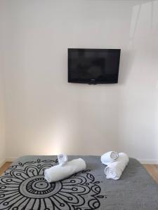 瓦倫西亞的住宿－Apartamento delux2，卧室配有2条毛巾和1张带1台平面电视的床