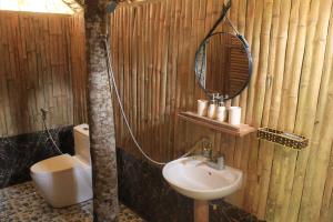 y baño con lavabo, espejo y aseo. en Pu Luong Homestay & Tours, en Hương Bá Thước