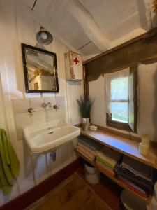 baño con lavabo, espejo y ventana en El Invernal de Vallobera en Pujayo