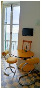 シラクーサにあるCasa Alfeoのテーブルと椅子2脚が備わる客室です。