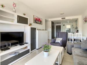 - un salon avec une télévision, un canapé et une table dans l'établissement Silene apartamento 3010, à Los Altos