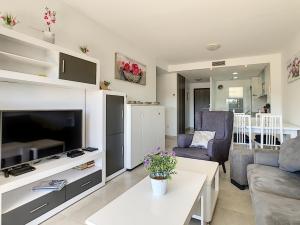 un soggiorno con una TV, un divano e un tavolo di Silene apartamento 3010 a Los Altos