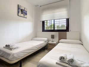 due letti in una stanza con pareti bianche e una finestra di Silene apartamento 3010 a Los Altos Altre 29 foto