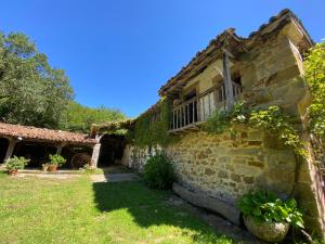 an old stone building with a balcony on it at El Invernal de Vallobera in Pujayo