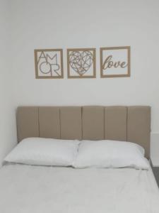 a bed with four pictures on the wall at Apto NOVO Sensacional Acqua Park com Piscina e Garagem in Pelotas +60 photos