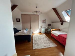 a bedroom with two beds and a desk and a window at La Maisonnette in Les Pieux