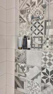 a shower in a bathroom with a tile floor at Finnem Rentals Jičínská in Prague