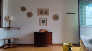 Cette chambre est dotée d'un mur blanc et d'une commode en bois. dans l'établissement Sant'Uguzzone Flat, à Milan