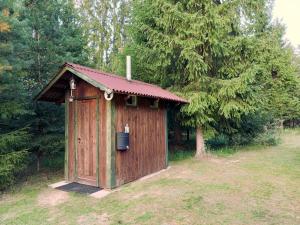 una casa exterior de madera en un campo con árboles en Vastseliina Metskond Camping en Vahtseliina