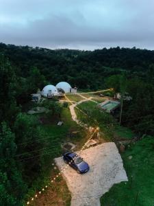 a car parked on a dirt road with two domes at Glamping Dream Domes Ismayilli in İsmayıllı