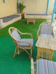two chairs and a table in a room with green grass at فيلا بيجو in Tunis