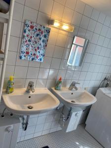 een witte badkamer met 2 wastafels en een spiegel bij Bauernhaus in der Bayrischen Rhön in Schönau an der Brend