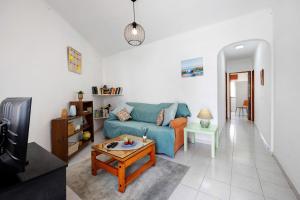 a living room with a blue couch and a table at Casa do Chico in Lagoa