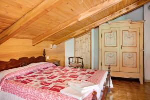 a bedroom with a bed and a wooden ceiling at Casa Sasia in Casteldelfino