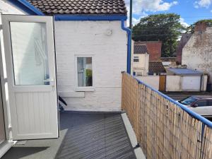 an open door to a white house with a balcony at No 27 Guisborough - 1 bed apartment in Guisborough