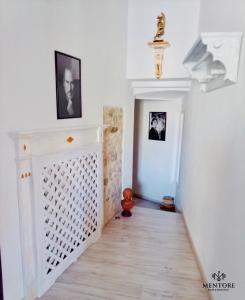 un pasillo con una puerta blanca y cuadros en la pared en MentoreR&B, en Noceto
