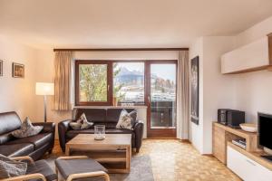 a living room with a couch and a tv at Haus Excelsior Top 21 in Seefeld in Tirol