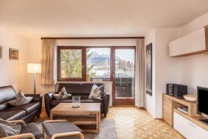 ein Wohnzimmer mit einem Sofa und einem TV in der Unterkunft Haus Excelsior Top 21 in Seefeld in Tirol