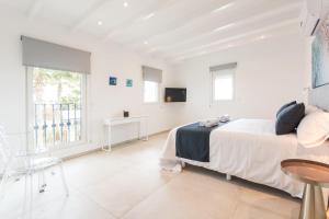 ein weißes Schlafzimmer mit einem Bett und einem Fenster in der Unterkunft Can Maties in Santa Margalida + 37 Fotos
