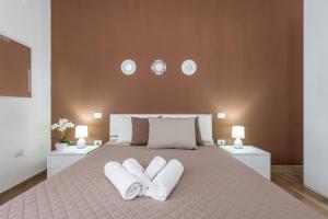 una camera da letto con un grande letto con due asciugamani bianchi di Villetta Mattia a Pula