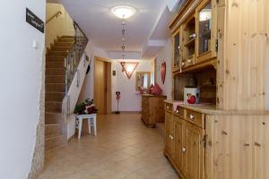 a large kitchen with wooden cabinets and a staircase at Apartments Gannerhof in Obertilliach