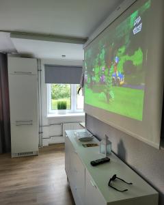 a room with a large screen with a video game on the wall at Comfort apartment in Rakvere in Rakvere