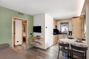 een woonkamer met een eettafel en een keuken bij Petalo Rosina's Home in Livigno