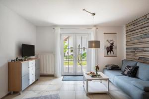 a living room with a blue couch and a tv at Ferienwohnung Hohfelsenblick in Seebach