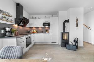 a kitchen with white cabinets and a stove at Hafenglück in Olpenitz