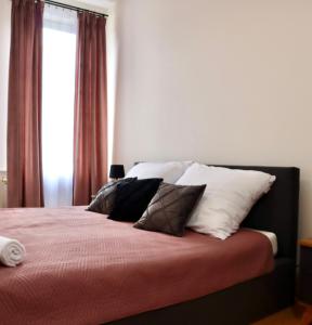 1 dormitorio con cama con almohadas y ventana en Apartament w kamienicy, en Ostróda
