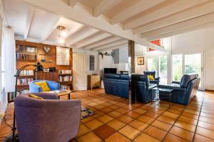 een woonkamer met banken en stoelen en een tafel bij Villa bleue in Sanguinet