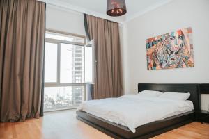 una camera con un letto e una grande finestra di City Center Deluxe Apartments a Baku