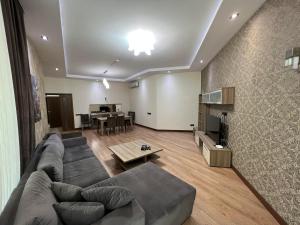 un soggiorno con divano e tavolo di City Center Deluxe Apartments a Baku