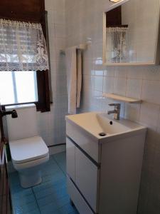 a bathroom with a toilet and a sink and a window at Apartamento bahía in Miami Platja