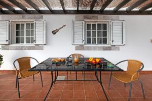 a table and chairs on a patio with windows at Casa Majos in Tesejerague