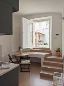 uma cozinha com escadas, uma janela e uma mesa em Casa Pátio do Megué em Évora