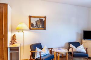 une chambre avec deux chaises, une table et un miroir dans l'établissement Haus Excelsior Top 3, à Seefeld in Tirol
