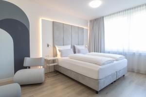 Un dormitorio con dos camas y una gran ventana. en zzzpace Smart-Hotel Bielefeld Zentrum, en Bielefeld
