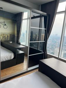 吉隆坡Vortex KLCC apartment by All Asia的一间卧室，里面有一张床和一扇大窗户。 更多39张照片