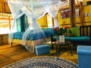 un dormitorio con 2 camas y una mesa con un jarrón de flores en Pu Luong Homestay & Tours, en Hương Bá Thước