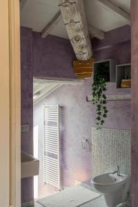 baño con paredes de color púrpura y lavamanos en Il Nido, en Buonconvento