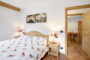 een slaapkamer met een bed, een tafel en een spiegel bij Casa Michela Bilocale in Valfurva