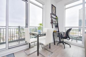 a dining room with a table and chairs and windows at The Splendid - Luxury 1BR Uptown Toronto in Toronto