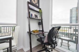 a desk and chair in a room with windows at The Splendid - Luxury 1BR Uptown Toronto in Toronto