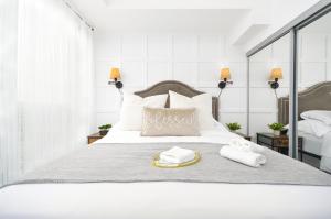 a bedroom with a white bed with two towels on it at The Splendid - Luxury 1BR Uptown Toronto in Toronto +25 photos