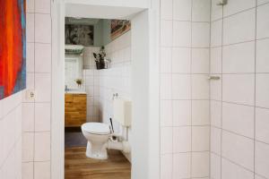 a white bathroom with a toilet and a sink at Charmanter Altbau zwischen Altstadt und Klinikum mit Parkplatz in Greifswald