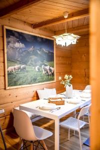 a dining room with a table and a painting of sheep at Apartament u Gabrysi in Białka Tatrzańska