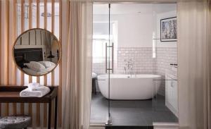 ein Badezimmer mit einer Badewanne und einem großen Spiegel in der Unterkunft The Black Bull Inn in Sedbergh